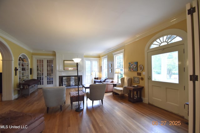1211 River Rd, Greenwood, MS 38930 - living room featuring wood finished floors, ornamental molding, french doors, a large fireplace, and built in features