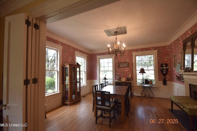 1211 River Rd, Greenwood, MS 38930 - dining area with a wainscoted wall, wallpapered walls, a chandelier, wood finished floors, and a fireplace