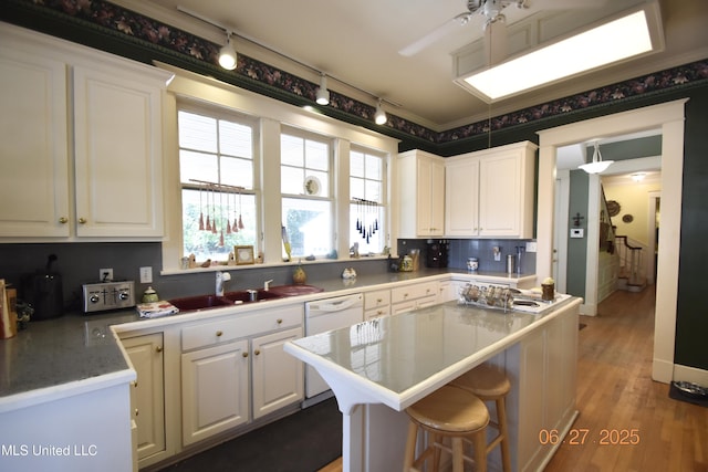 1211 River Rd, Greenwood, MS 38930 - kitchen featuring white cabinets, a kitchen island, rail lighting, and white dishwasher