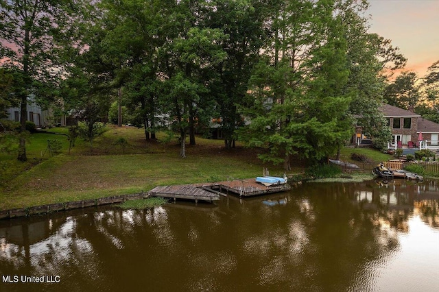 view of dock featuring a yard and a water view