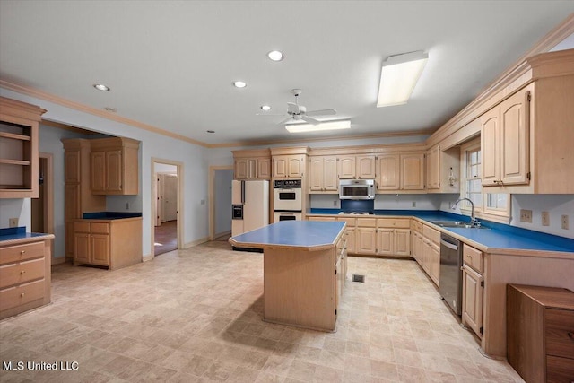 kitchen featuring appliances with stainless steel finishes, sink, a center island, ceiling fan, and ornamental molding