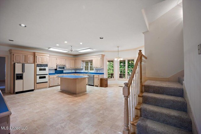 kitchen featuring a kitchen island, hanging light fixtures, crown molding, light brown cabinetry, and appliances with stainless steel finishes