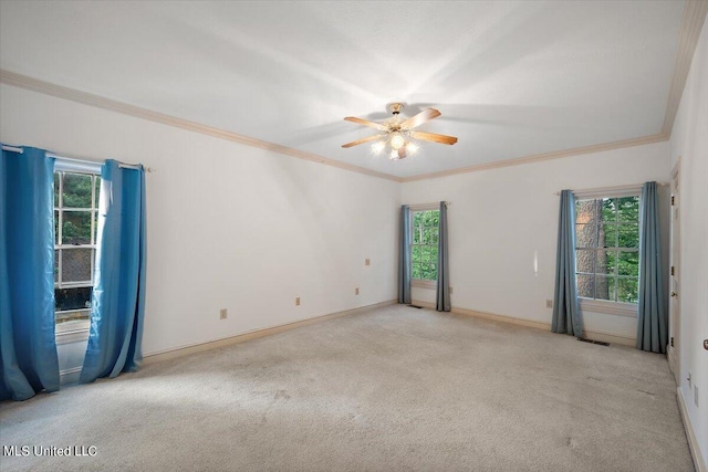 carpeted empty room featuring ornamental molding, ceiling fan, and a wealth of natural light