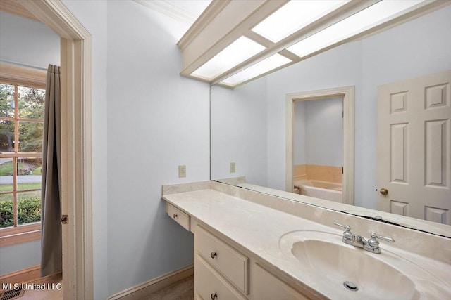 bathroom featuring vanity, vaulted ceiling, a bathtub, and a healthy amount of sunlight