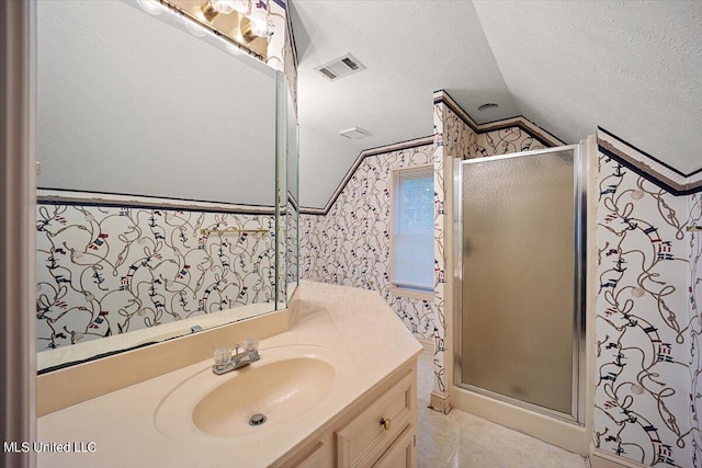 bathroom with vanity, a textured ceiling, lofted ceiling, and an enclosed shower