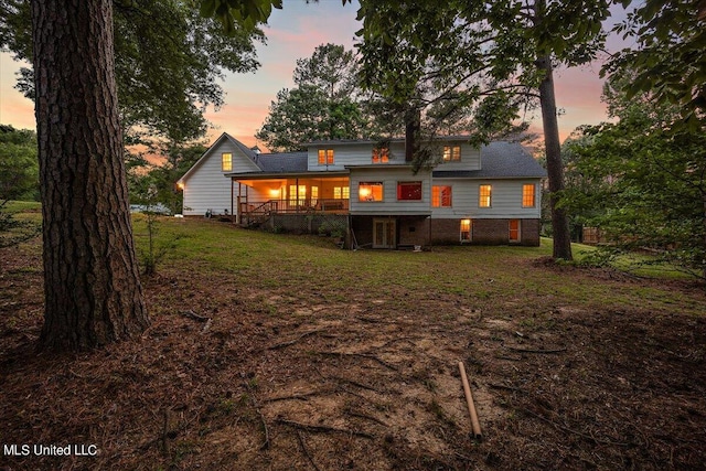 back house at dusk featuring a yard