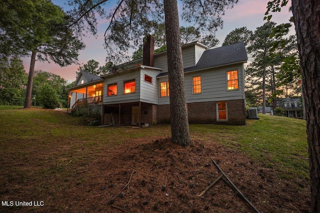 back house at dusk with a lawn