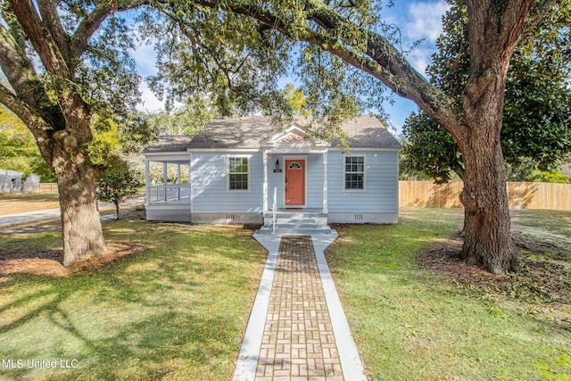 bungalow-style home with a shingled roof, a front lawn, fence, and crawl space