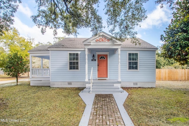 bungalow-style home with a front lawn, fence, roof with shingles, and crawl space