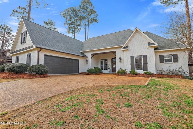 view of front facade featuring an attached garage, brick siding, a shingled roof, concrete driveway, and a front yard