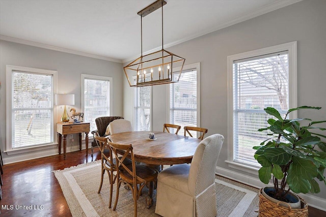 dining room with dark wood finished floors, a healthy amount of sunlight, crown molding, and baseboards