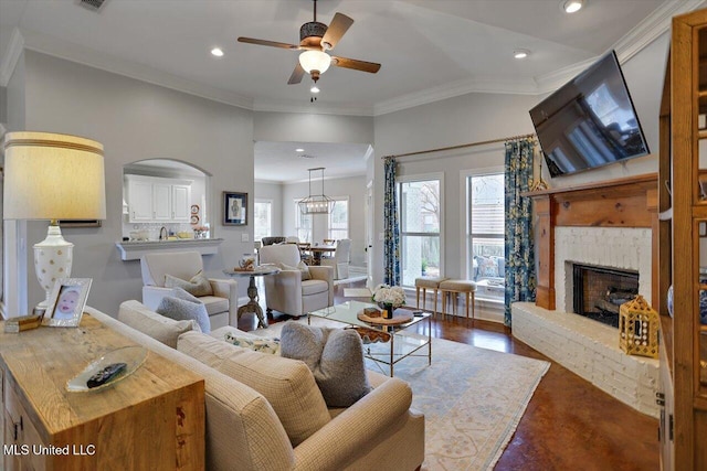 living area with crown molding, recessed lighting, a ceiling fan, a large fireplace, and wood finished floors