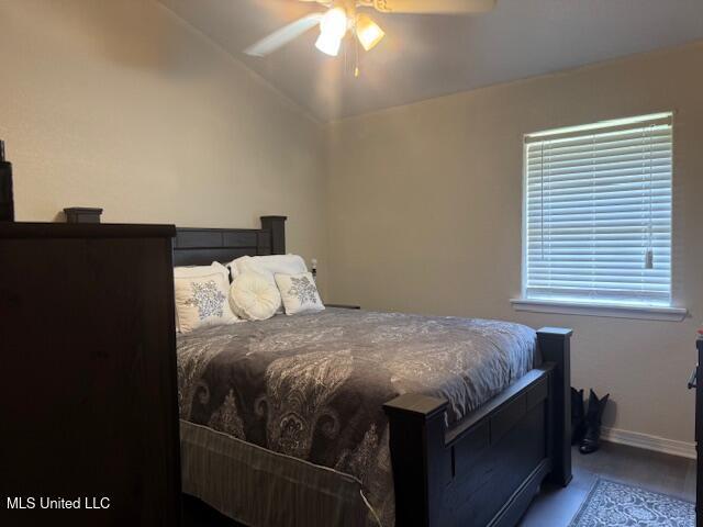 bedroom featuring lofted ceiling, baseboards, and ceiling fan