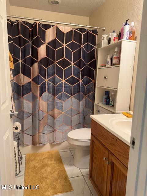 full bath featuring a textured wall, toilet, vanity, and a shower with curtain