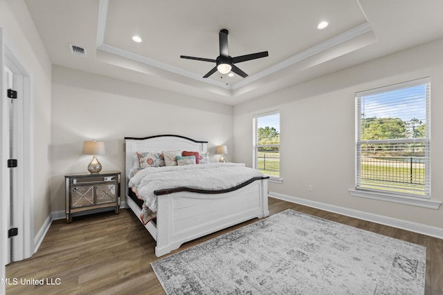 bedroom featuring a raised ceiling, visible vents, dark wood finished floors, and baseboards