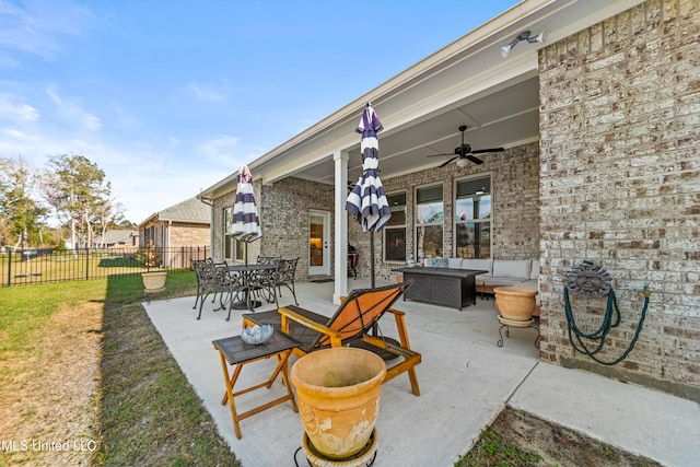 view of patio / terrace with ceiling fan, fence, and an outdoor living space