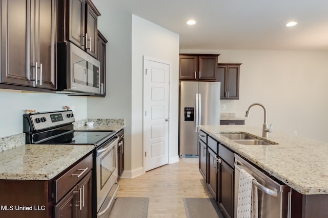 15581 Ollie Ln, Biloxi, MS 39532 - kitchen with appliances with stainless steel finishes, a sink, light wood-style floors, dark brown cabinets, and recessed lighting