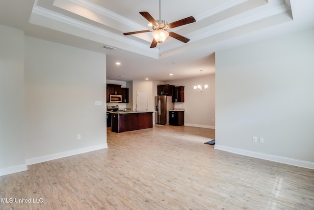 15581 Ollie Ln, Biloxi, MS 39532 - unfurnished living room featuring a tray ceiling, a chandelier, ornamental molding, a ceiling fan, and light wood-style flooring