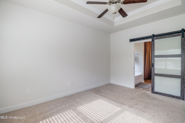 15581 Ollie Ln, Biloxi, MS 39532 - unfurnished room featuring carpet, a barn door, ceiling fan, baseboards, and a raised ceiling