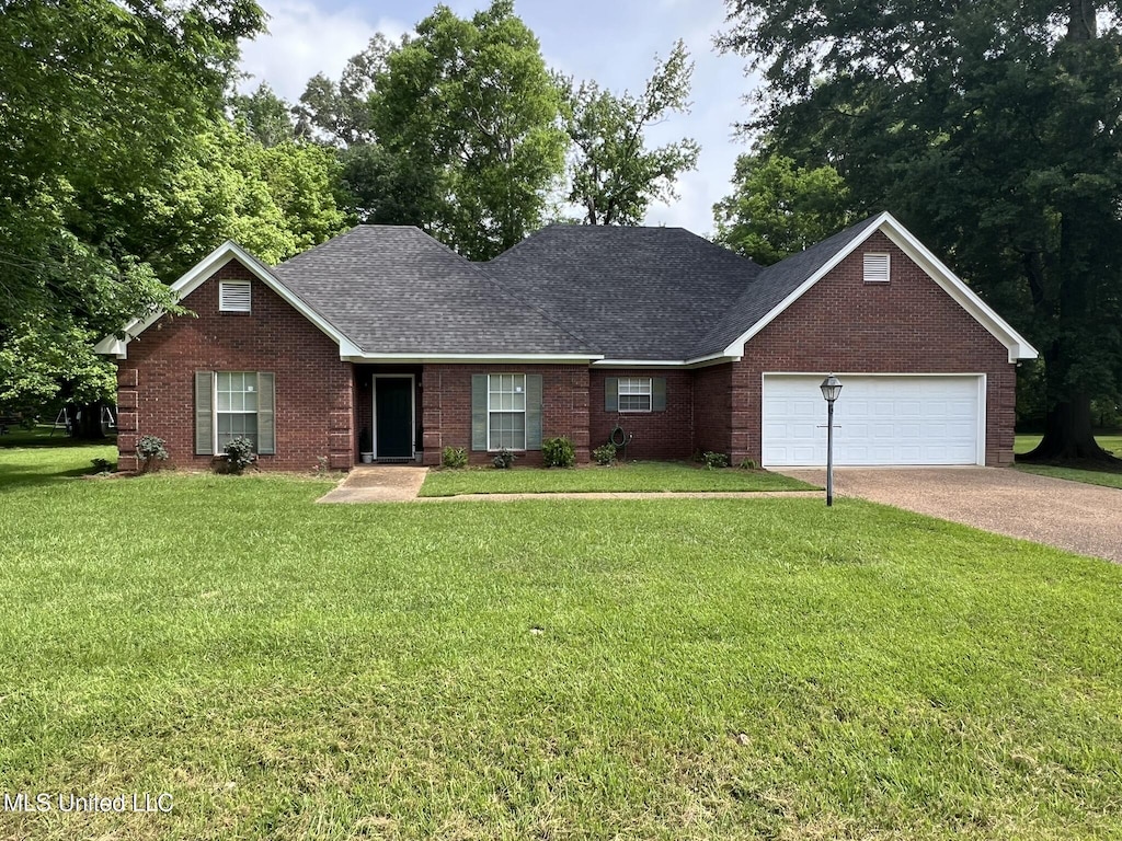 123 Wildwood Blvd, Jackson, MS 39212 - view of front of house with a garage, a front yard, brick siding, driveway, and roof with shingles
