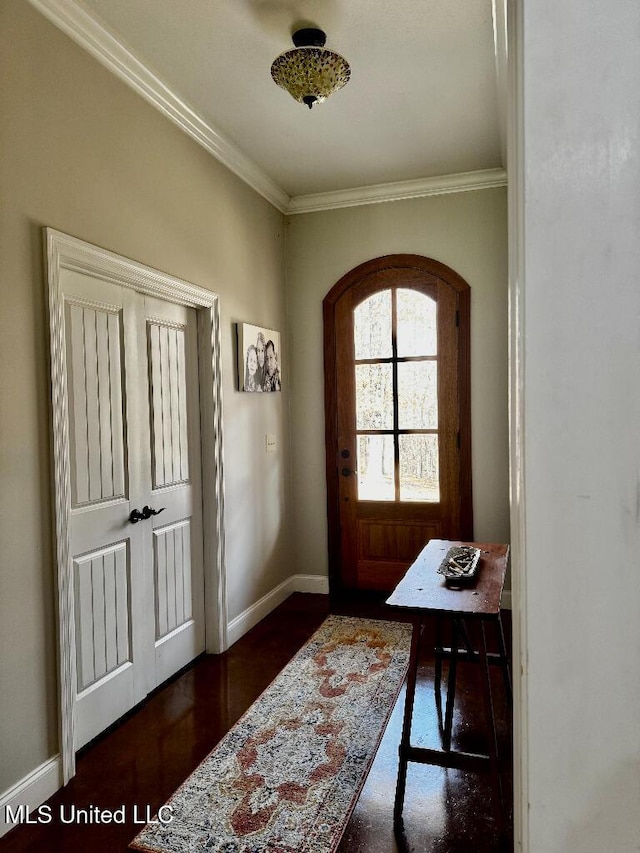 foyer featuring crown molding and dark wood-type flooring