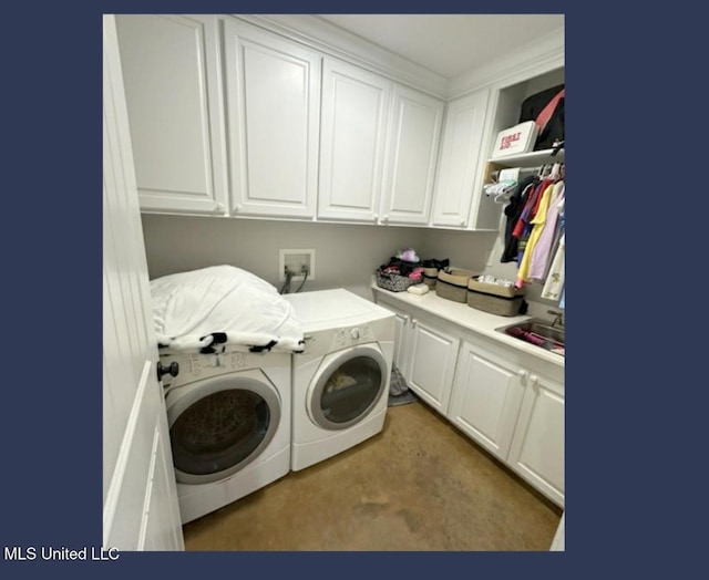 clothes washing area with cabinets, sink, and independent washer and dryer