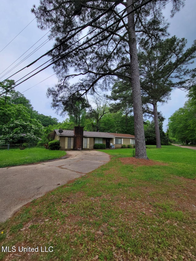 ranch-style home with driveway and a front lawn