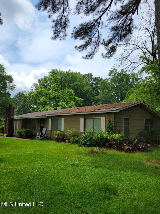 view of front of property featuring a front lawn and a chimney
