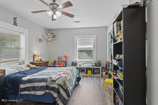 284 Osborn Moody Rd, Poplarville, MS 39470 - bedroom featuring multiple windows, wood finished floors, and a ceiling fan