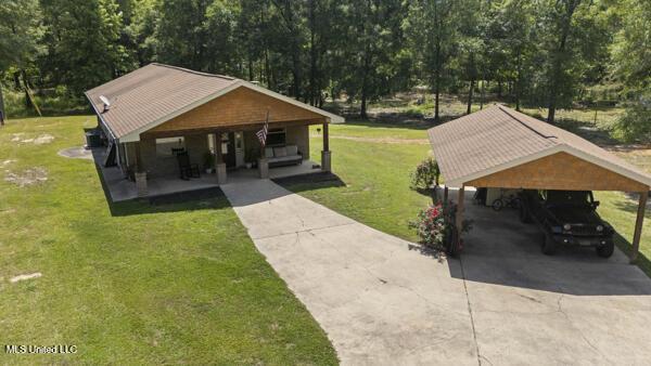 284 Osborn Moody Rd, Poplarville, MS 39470 - surrounding community with driveway, a yard, a detached carport, and view of wooded area