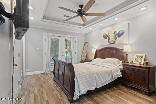 284 Osborn Moody Rd, Poplarville, MS 39470 - bedroom with french doors, a tray ceiling, access to exterior, light wood finished floors, and ornamental molding