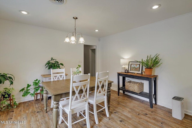 dining room featuring light wood finished floors, a notable chandelier, and recessed lighting