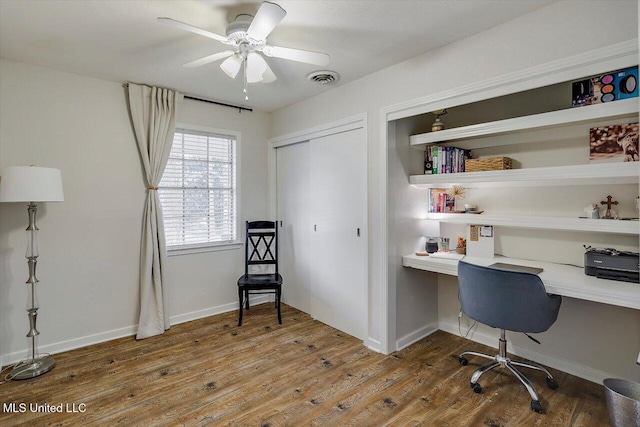 home office featuring a ceiling fan, visible vents, built in study area, and wood finished floors