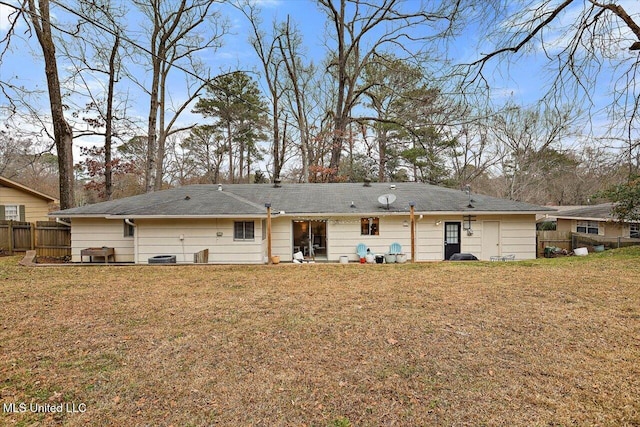 rear view of house featuring a yard and fence