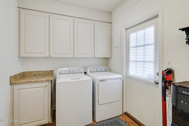 washroom featuring separate washer and dryer, wood finished floors, cabinet space, and a healthy amount of sunlight