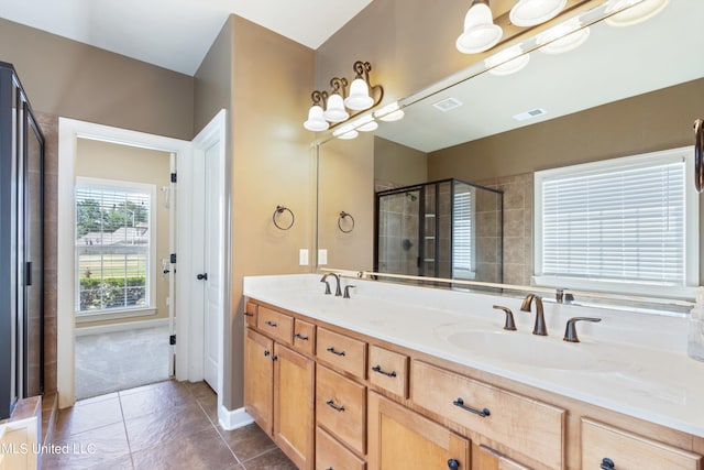 bathroom with vanity, a shower with door, and tile patterned flooring