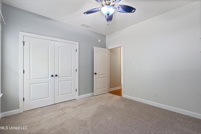 unfurnished bedroom with light colored carpet, ceiling fan, and a closet