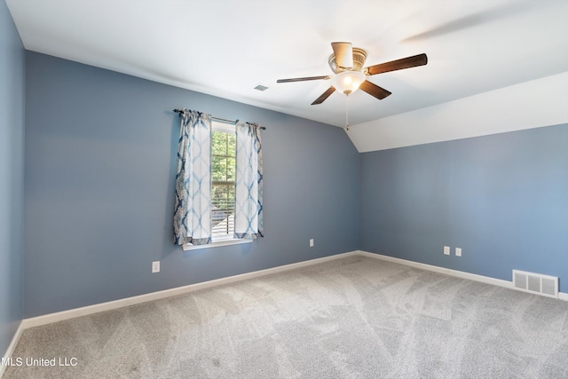 carpeted spare room featuring ceiling fan and vaulted ceiling