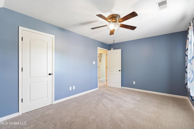 empty room featuring ceiling fan and light colored carpet