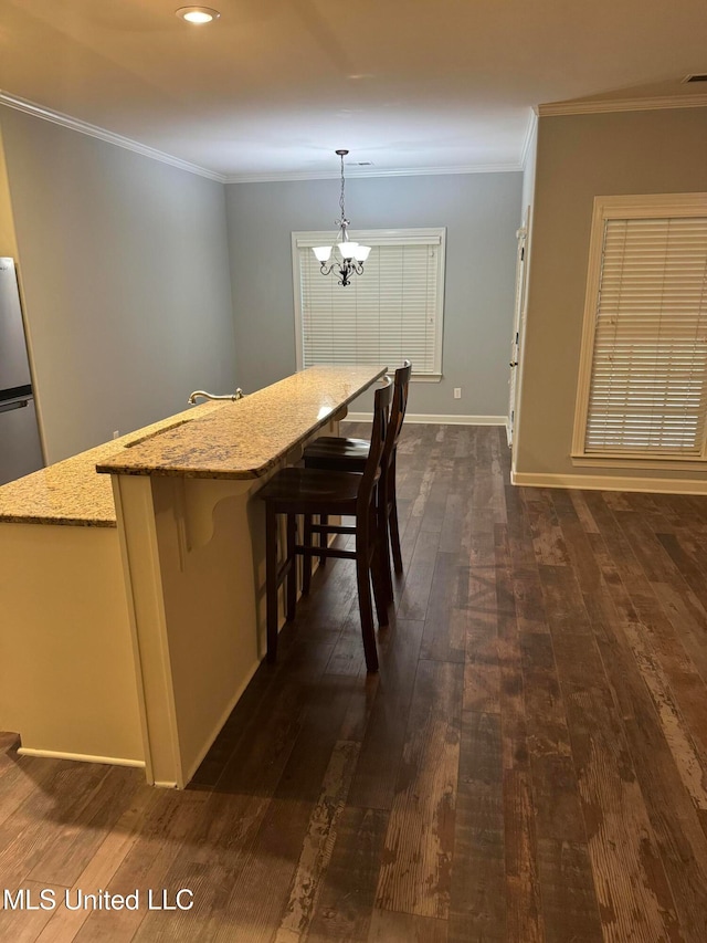 unfurnished dining area featuring ornamental molding, dark hardwood / wood-style floors, and an inviting chandelier