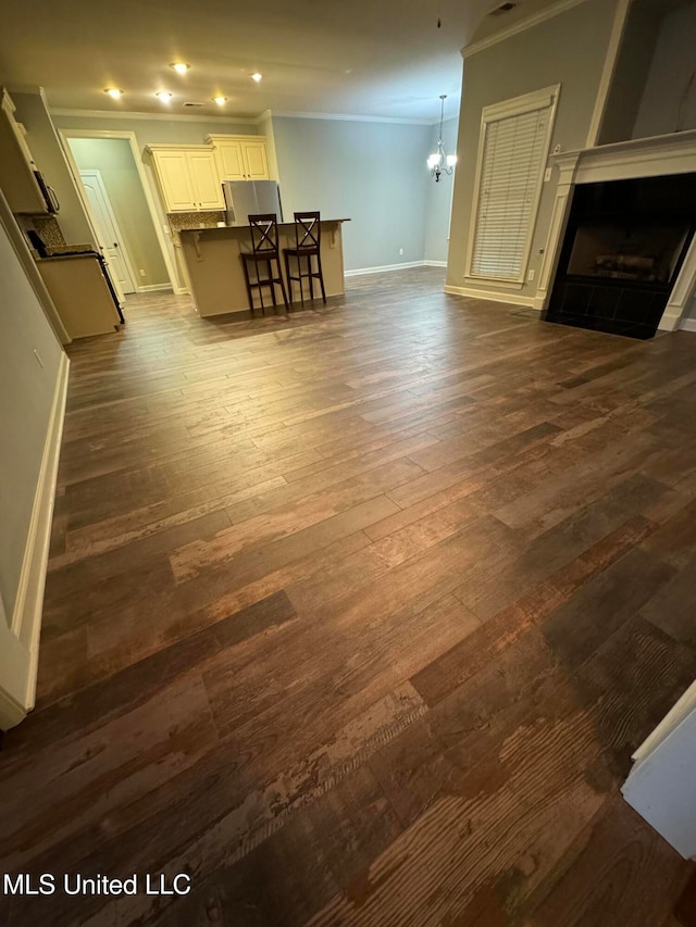 unfurnished living room with a chandelier, crown molding, dark hardwood / wood-style floors, and a fireplace