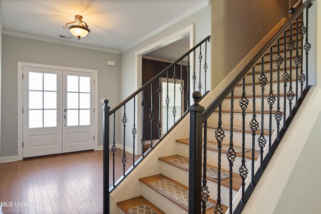 entryway with a healthy amount of sunlight, french doors, ornamental molding, and hardwood / wood-style flooring