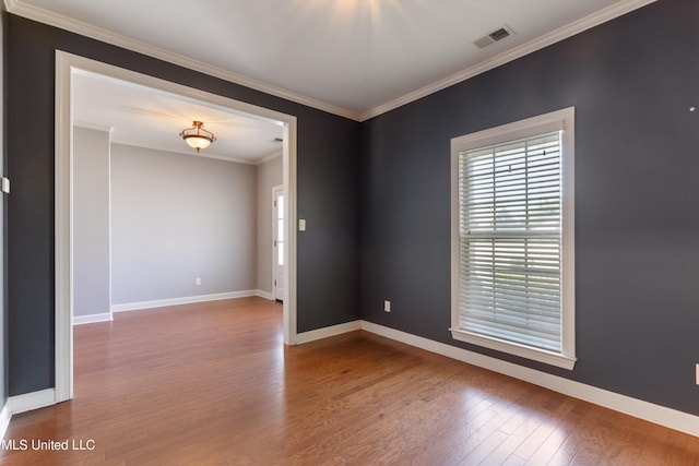 unfurnished room with ornamental molding and hardwood / wood-style floors