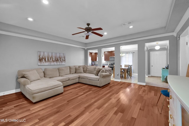 living room featuring ceiling fan, light wood-type flooring, and ornamental molding