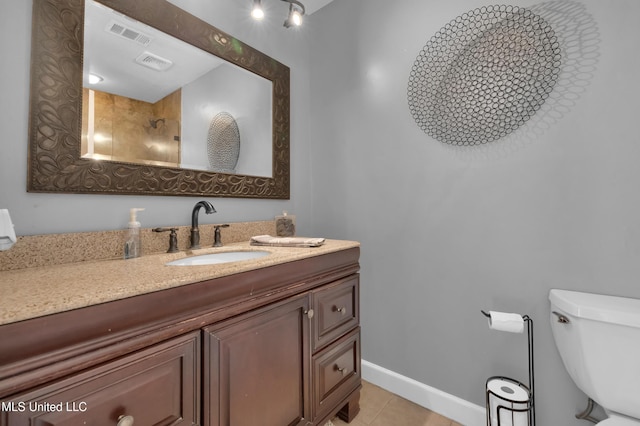 bathroom featuring toilet, vanity, and tile patterned floors