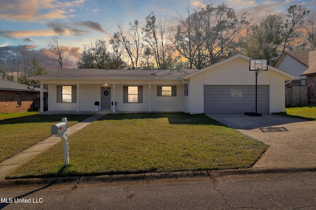 ranch-style home with covered porch, a garage, and a lawn