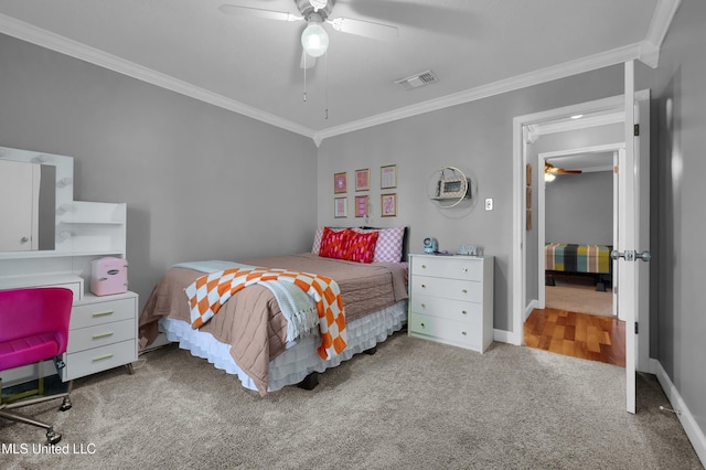 carpeted bedroom featuring ceiling fan and ornamental molding