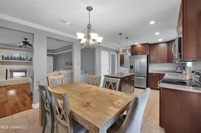 dining area featuring light tile patterned flooring, crown molding, a textured ceiling, built in shelves, and ceiling fan with notable chandelier