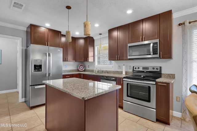 kitchen featuring decorative light fixtures, crown molding, stainless steel appliances, and a kitchen island