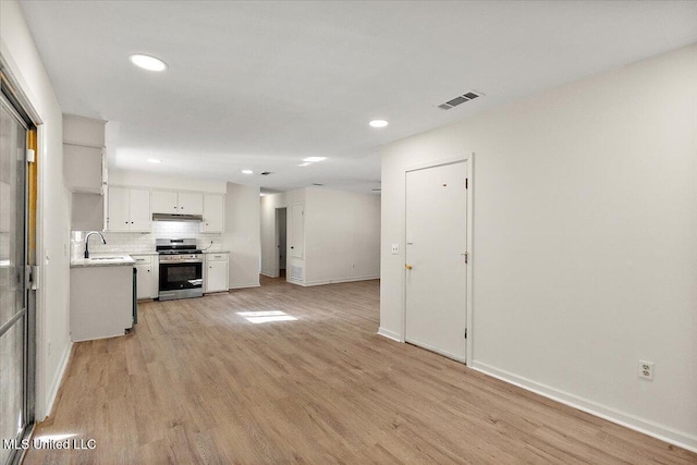 1399 Dorgan St, Jackson, MS 39204 - kitchen with sink, decorative backsplash, light wood-type flooring, stainless steel range oven, and white cabinetry